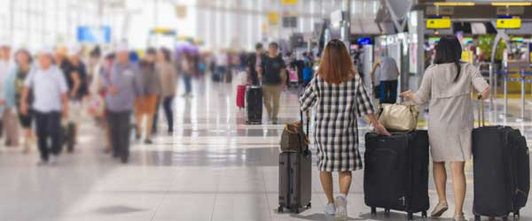 Two women at a busy airport